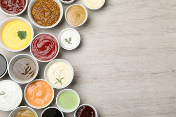 Obraz na płótnie Canvas Many different sauces on white wooden table, flat lay. Space for text