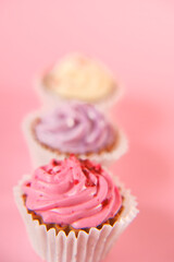 Cream cupcakes.cakes on a pink background.Cream dessert. Assorted sweet table. Sweets and desserts.
