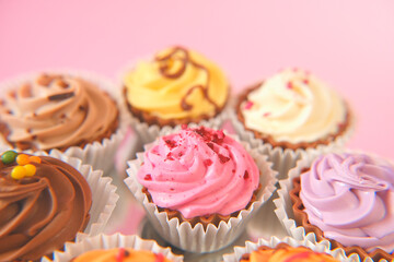 Cream cupcakes.cakes on a pink background.Cream dessert. Assorted sweet table. Sweets and desserts. Baked goods and desserts