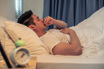 Asian sick handsome male in pajamas sleep in the dark night in bedroom. 