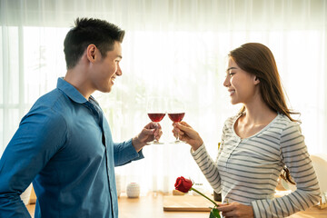 Asian young couple clinking glass of wine and drink on valentine's day.