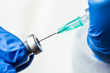Fototapeta Detail closeup of syringe needle in ampoule vial,UK nurse taking injection shot obraz