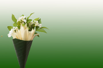 white jasmine, champaka arrangement in cone flat lay postcard style on background  green