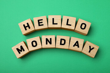 Wooden cubes with message Hello Monday on green background, flat lay © New Africa