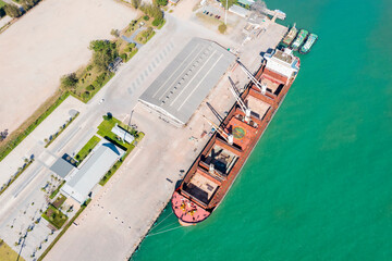 Aerial drone top view of containers cargo ship at industrial import-export port. Business logistic import and export freight transportation by container ship in open sea