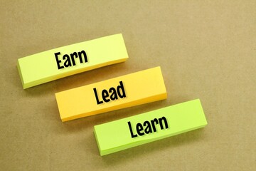 colored paper with three words Learn Lead And Earn. how to make money