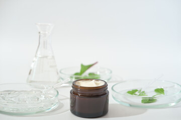 laboratory developed cream with natural ingredients. lab glassware, petri dishes with green leaves, substances and liquids. natural cosmetic ingredients.