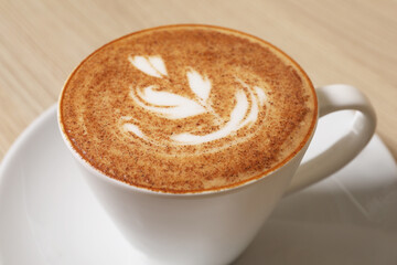 Cup of aromatic coffee on table, closeup