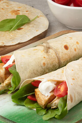 Wrap of arugula, grilled chicken meat, tomatoes and cream cheese.