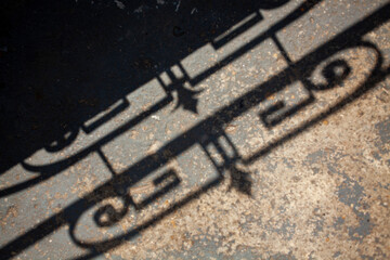 Fototapeta premium Geometric pattern fence shadow on sidewalk