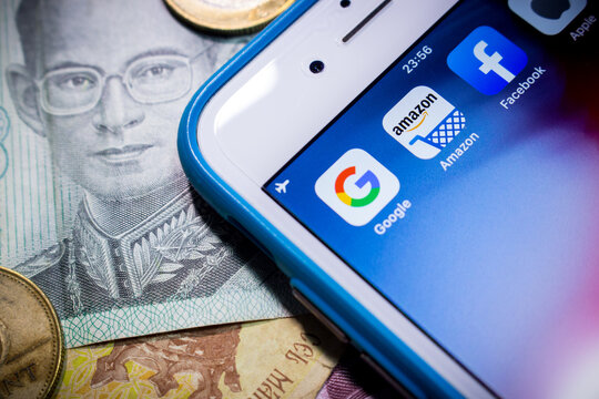 Kumamoto, Japan - Oct 13 2019 :
Concept image of GAFA on iPhone & money (coins & bills)
Google, Amazon, Facebook and Apple are the 4 US multinational companies that dominated cyberspace during 2010s.