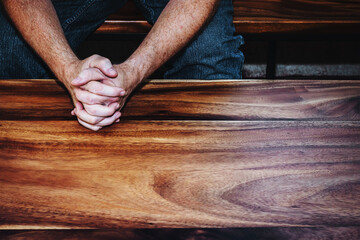 Close up of a man hands praying to God on a wooden table , Christian prayer, trust and faith in God concept with copy space for your text, believer prayer and encouragement. 