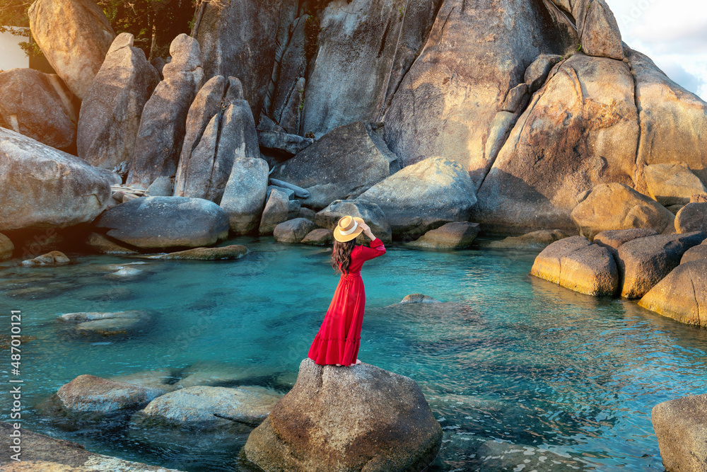 Poster tourist standing on the rock near grandfather and grandfather rock (hin ta and hin yai rocks) on the