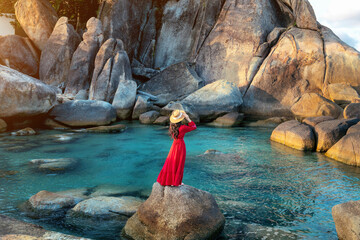 Tourist standing on the rock near Grandfather and grandfather rock (Hin Ta and Hin Yai Rocks) on the Lamai Beach, Koh Samui, Thailand.