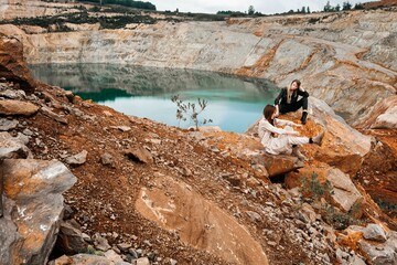 Girls in a post-apocalyptic place, a quarry with red earth and stones in work clothes