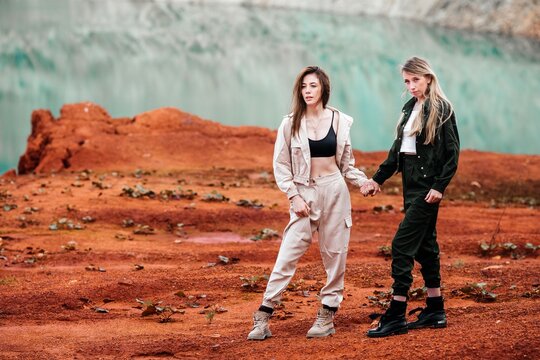 Girls in a post-apocalyptic place, a quarry with red earth and stones in work clothes