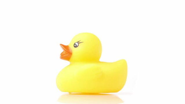 Toy yellow duck rotating on a white background