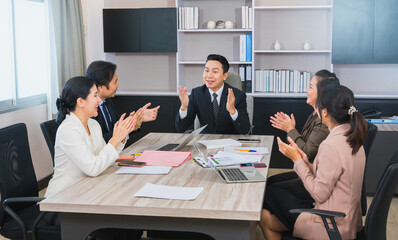manager and workers happy on business success in corporate meeting