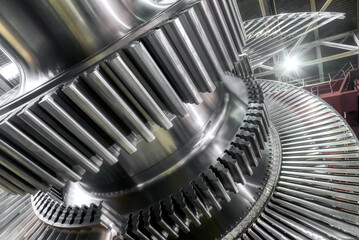 Large steam turbine with shiny blades and holes at plant