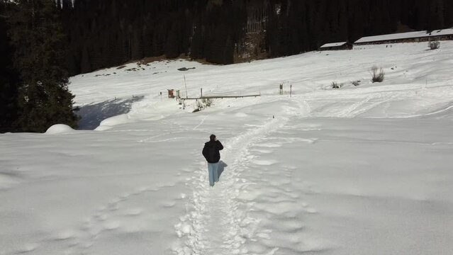 Man walking in in a snowy mountain path