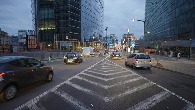 Cars moving between symmetrical road markers in the city at twilight. Brussels, Belgium