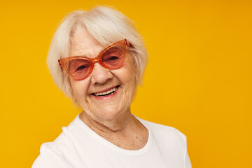 smiling elderly woman vision problems with glasses yellow background