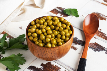 Canned green peas in a wooden bowl. Homemade fermented food. copy space