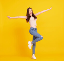 Fototapeta na wymiar Happy Asian girl jumping and celebrating isolated over yellow
