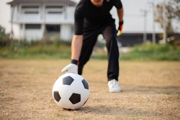 Sports and recreation concept a male goalkeeper standing in front of the goal throwing a ball as distributing in to a player after protecting the goal