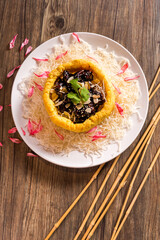 deep fried crispy yam taro pumpkin ring with barbeque pork ribs and sliced almond seed in dark soy sweet sauce in plate on bamboo wood table asian cafe Chinese restaurant banquet halal food menu