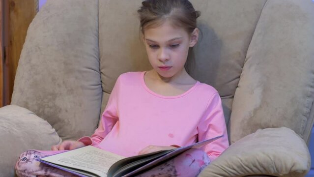 Ten years old chearful girl reeding the book and surprised
