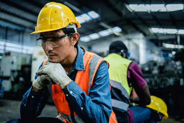 Engineer or Factory worker feeling tired from hard work in a factory, weak, hopeless, burned out,...