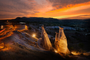 Dramatic sky above the symbol of Cappadocia with fabulous chimneys illuminated by lanterns