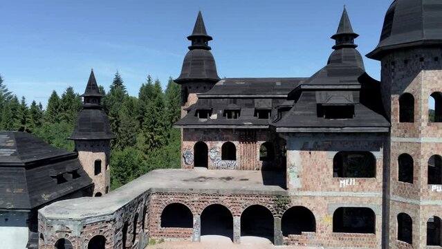 Unfinished castle building of Lapalice in Poland, aerial fly away shot
