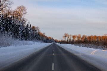 Fototapeta na wymiar Winter track in the Siberian taiga. An icy winter highway runs through the snow and taiga. A section of the highway in the Khanty-Mansi Autonomous Okrug - Yugra between Khanty-Mansiysk and the city of
