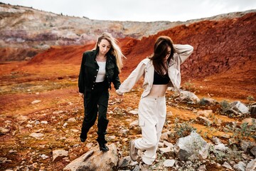 Girls in a post-apocalyptic place, a quarry with red earth and stones in work clothes