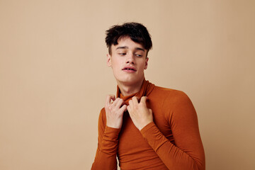 handsome guy stylish hairstyle brown turtleneck light background unaltered