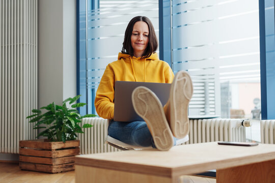 Woman of 40s wearing casual outfit while working on the laptop