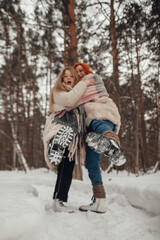Fototapeta na wymiar Two girls having fun in the winter forest