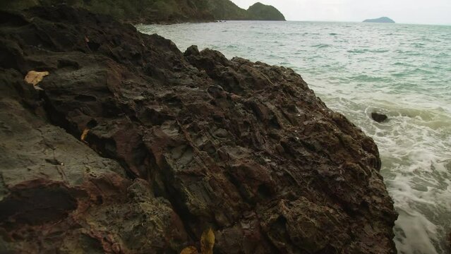 Pretty woman meditates, relaxes on rock crack reef hill in stormy morning cloudy sea. Concept feminine, sexual vaginal health, hygiene, womanly, freedom, fresh. Mother of ocean gives birth to him