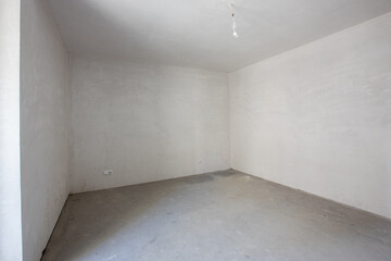 New empty room under construction. Plaster walls. New home. Concrete walls. Interior renovation.