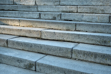 Close-up stone steps texture with space for text. The edges and corners of the stone granite stairs. Concrete fragments of steps architecture. Beautiful grey stair steps.