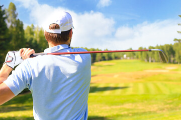 Athletic young man playing golf in golfclub.