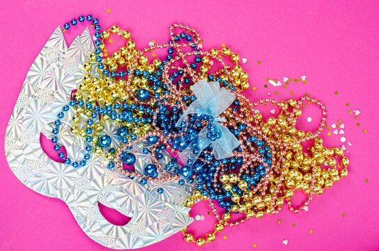 Color mardi gras beads, masks on bright background. Studio Photo
