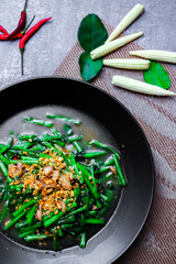 Stir-fried morning glory in a black dish 