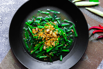 Stir-fried morning glory in a black dish 