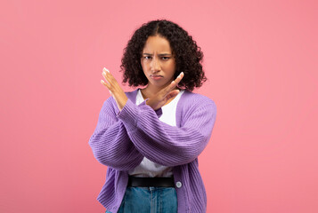 Millennial African American woman gesturing STOP, refusing something on pink studio background