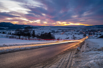 mountain road in snowy winter during a magnificent sunset