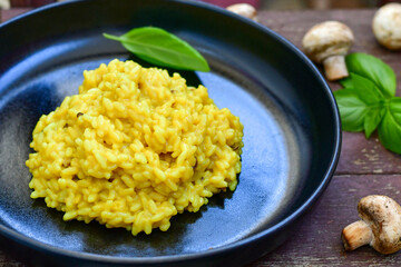  Italian  creamy Risotto Milanese  with Parmesan cheese and fresh basil on rustic background