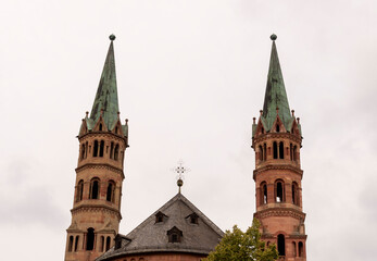 Fototapeta na wymiar Brick colored towers with bronze green roofs at Würzburger Cathedral or Würzburger Dom and the apse roof seen from the presbitery side